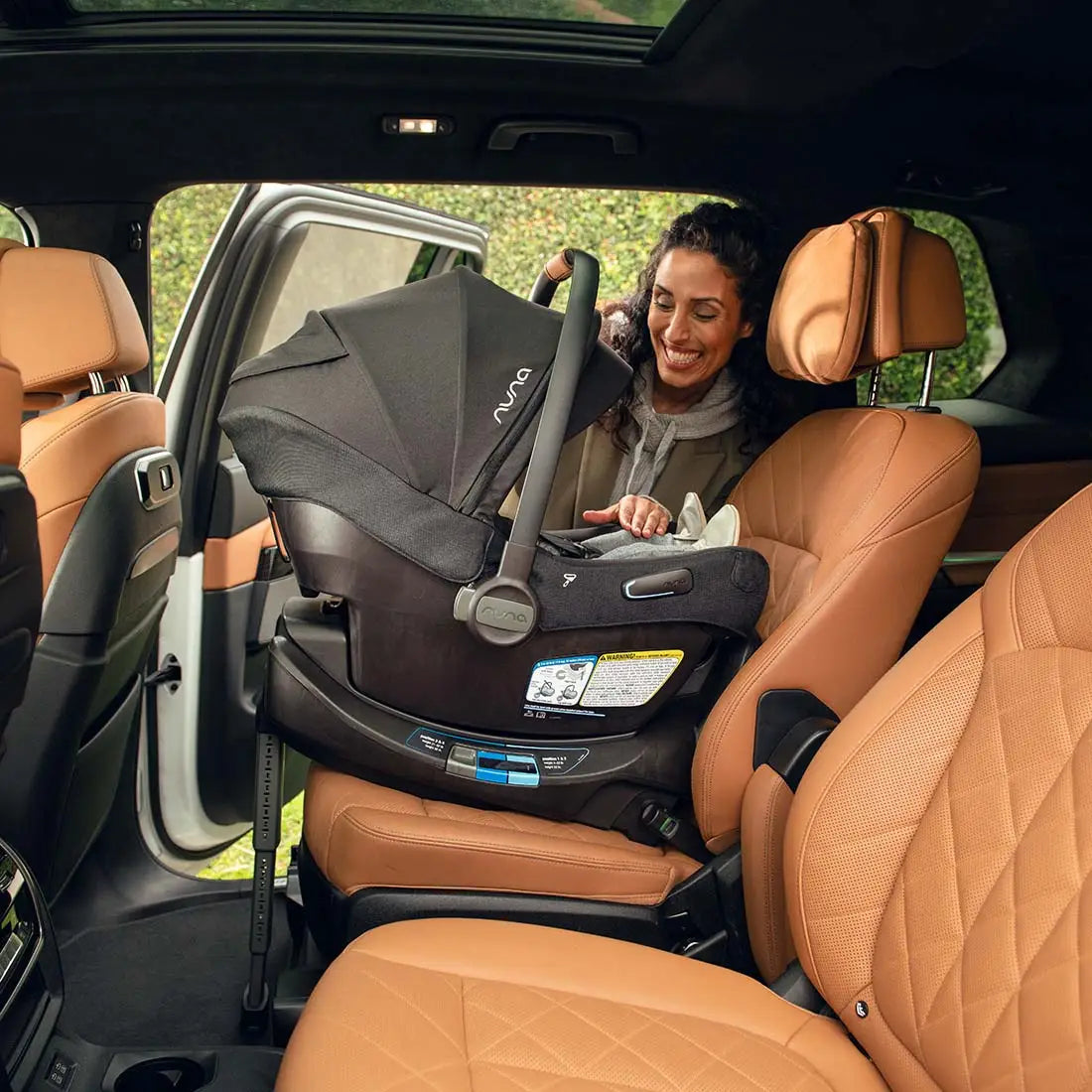 Woman adjusting a car seat in a vehicle with brown leather seats